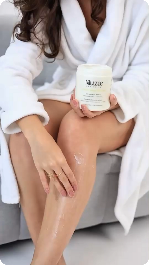 Mulher de roupao aplicando creme na perna